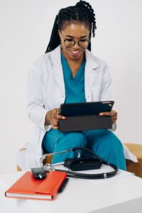 Black female doctor reviewing consultation notes on a tablet, smiling